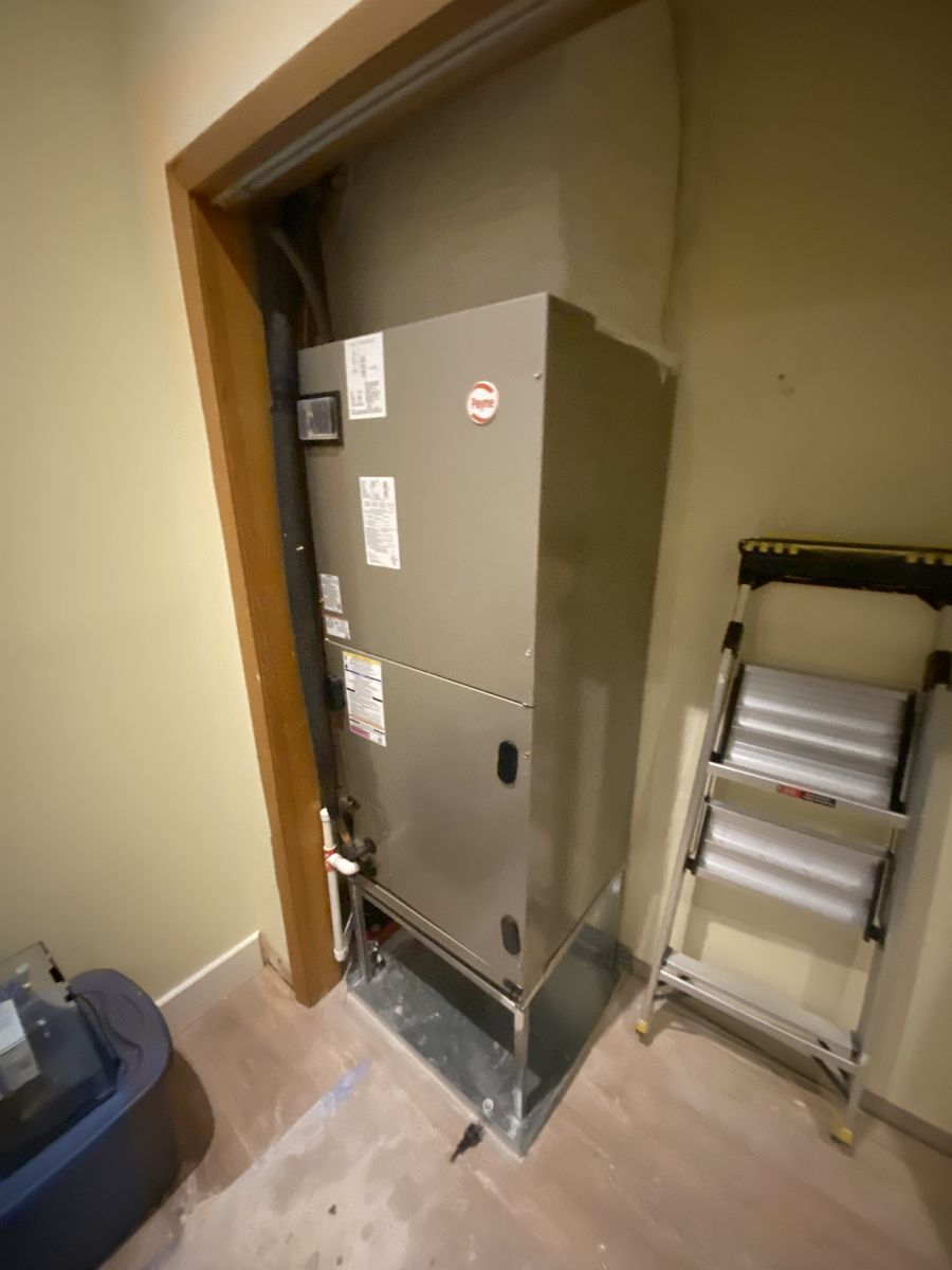 Bryant air handler installed on a metal stand inside an interior utility closet