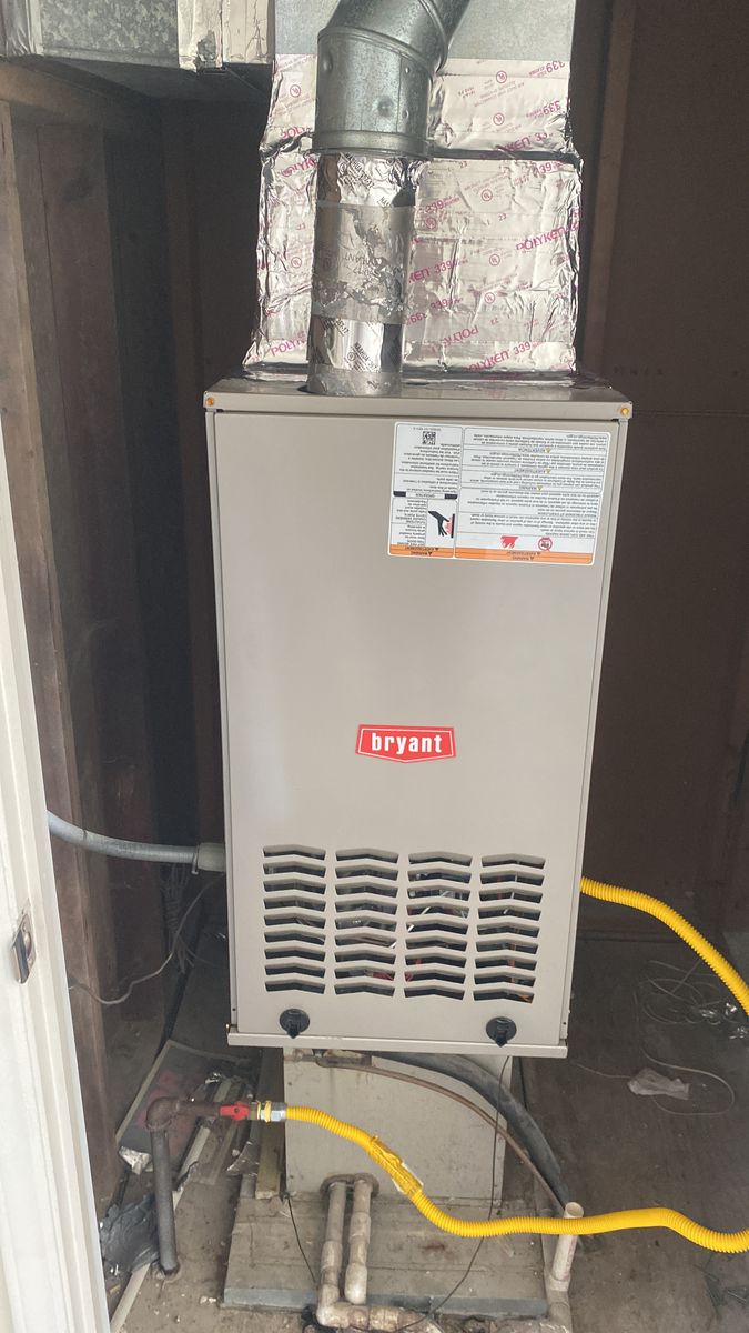 Bryant gas furnace installed in a utility closet with new flue pipe and gas line