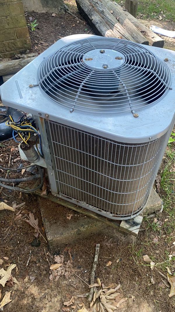 Close-up of an outdoor AC condenser with the service panel open and wiring exposed for electrical diagnostics