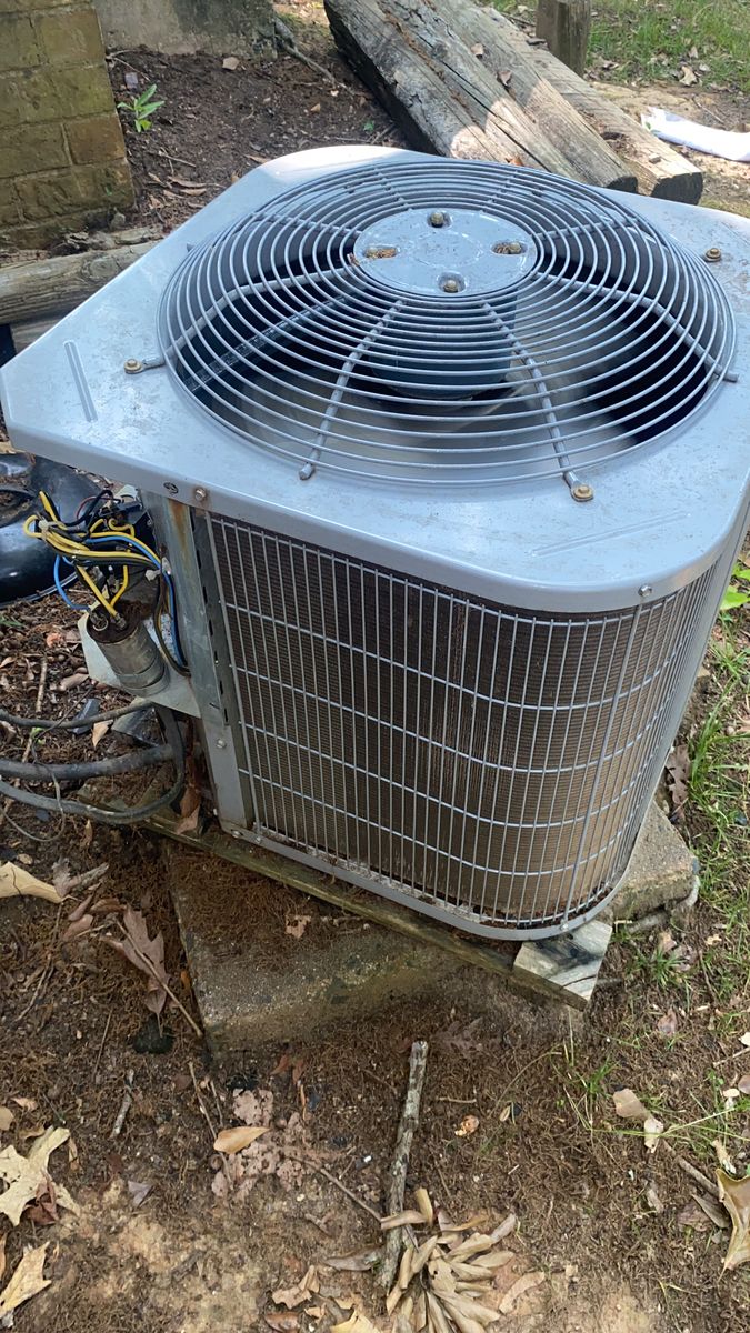 Close-up of an outdoor AC condenser with the service panel open and wiring exposed